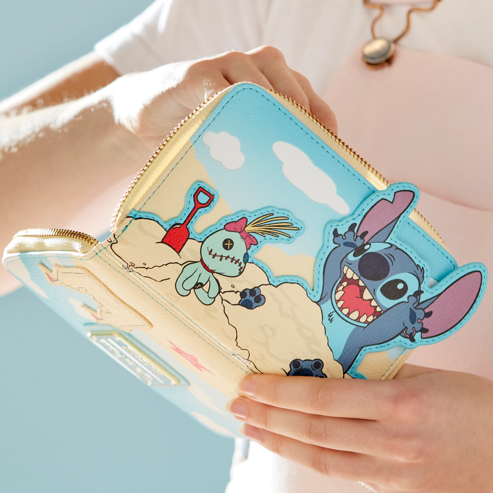 Cartoon stitch wallet held by a person with a light blue background